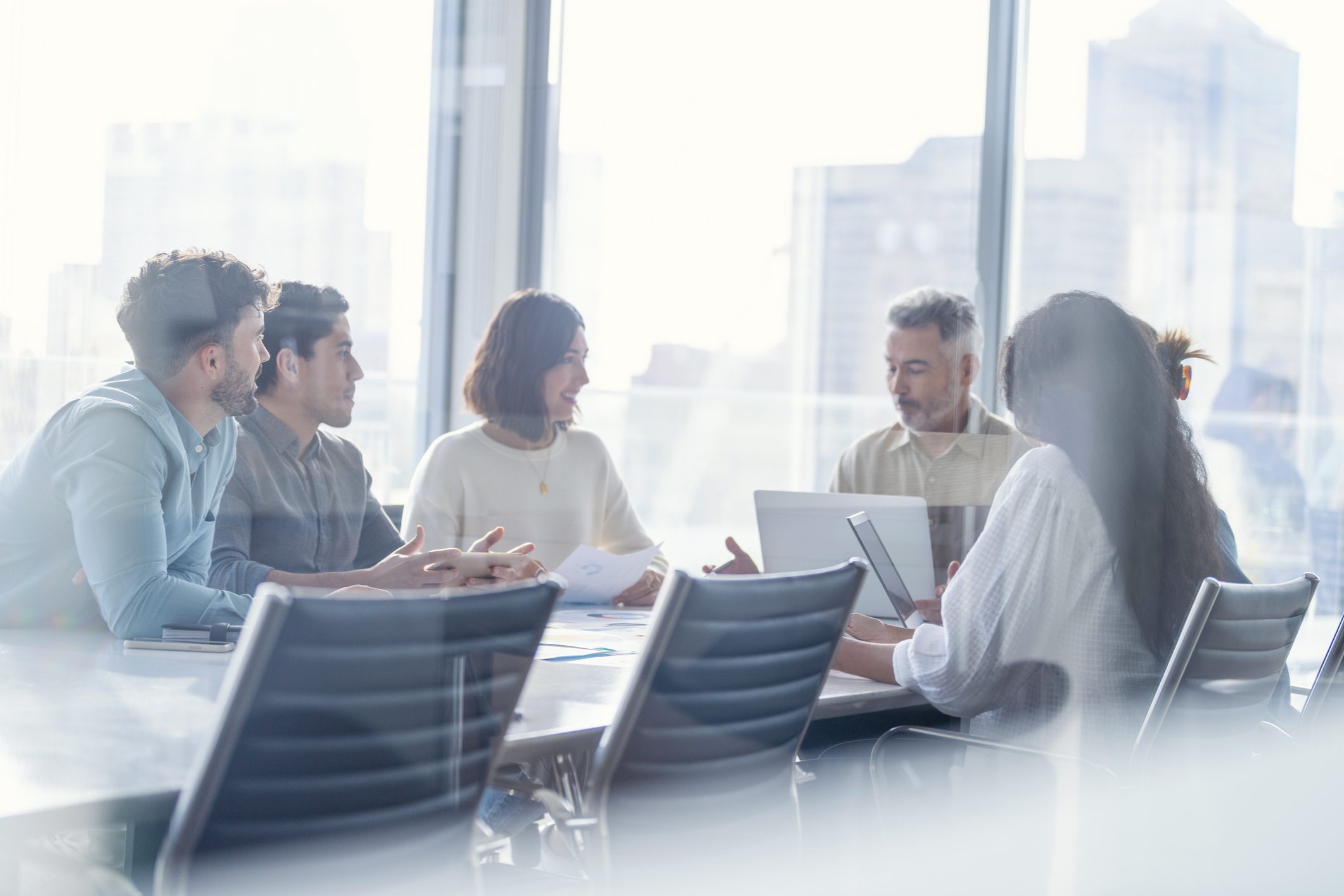 A group of people sitting around a table in a conference room.