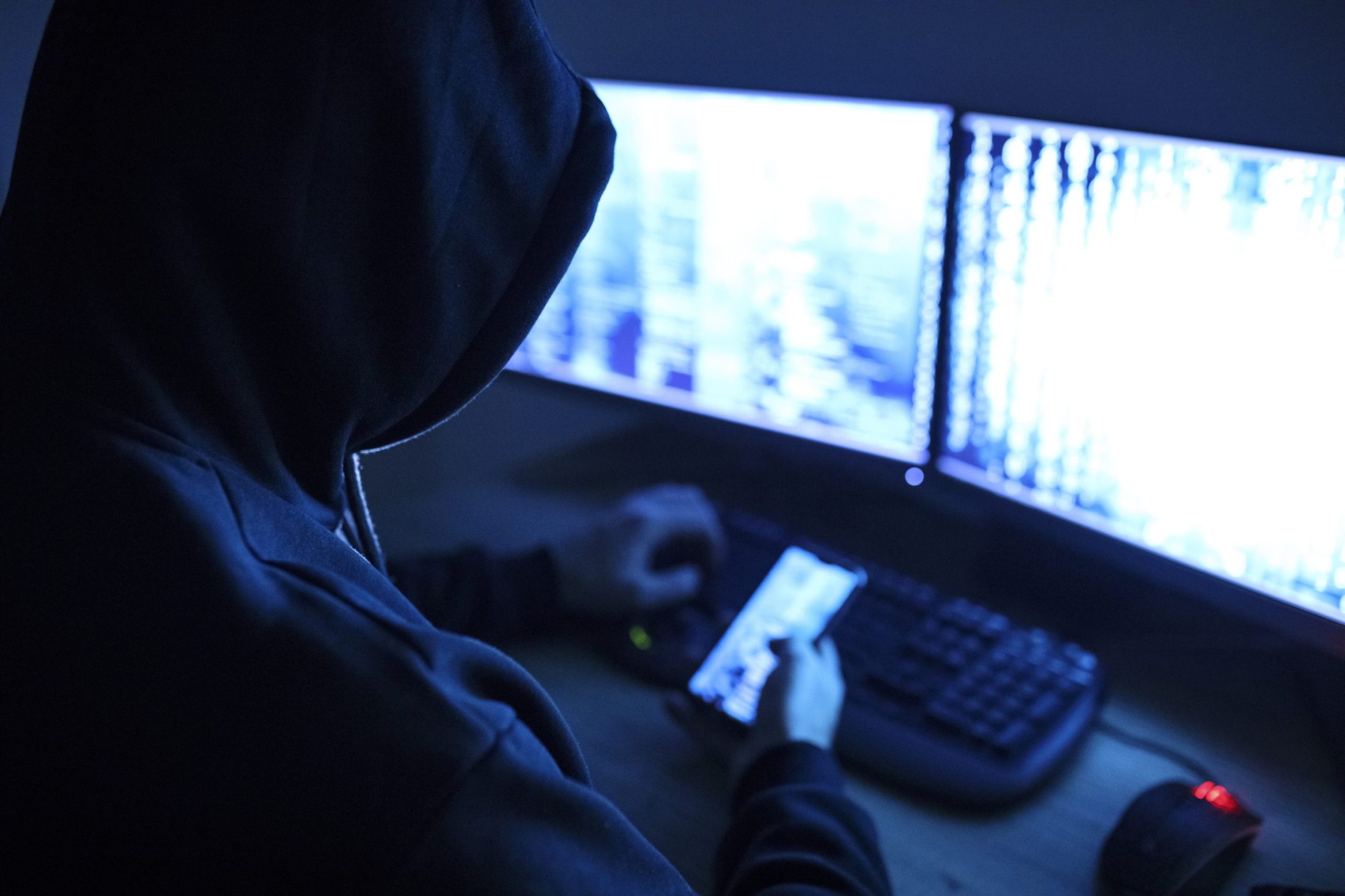 A person in a hoodie is using a computer.