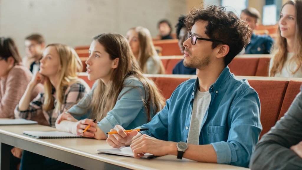 A group of students sitting in a lecture hall.