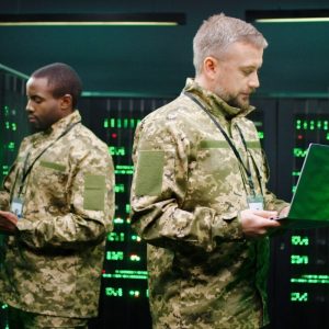 Deux hommes en tenue de camouflage dans une salle de serveurs.