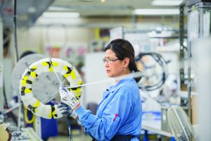 Un scientifique vêtu d'une blouse bleue mène des expériences dans un laboratoire.