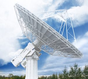 Une antenne parabolique blanche au milieu d'un champ.