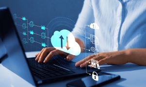 A woman using a laptop with a cloud icon on it.