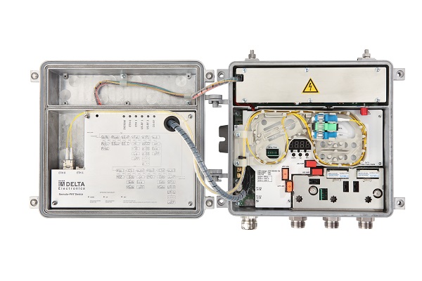 Open electronic control box with various circuits, cables, and components, including labeled connectors and a warning symbol. The box exterior has a partly visible brand label reading "Delta Electronics.