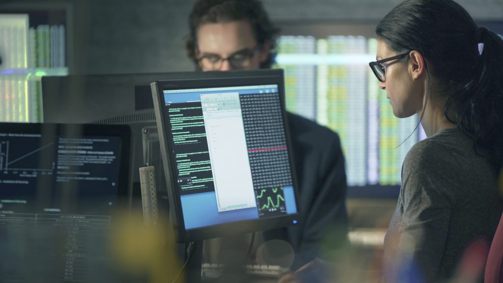 Two people working on computers in an office.