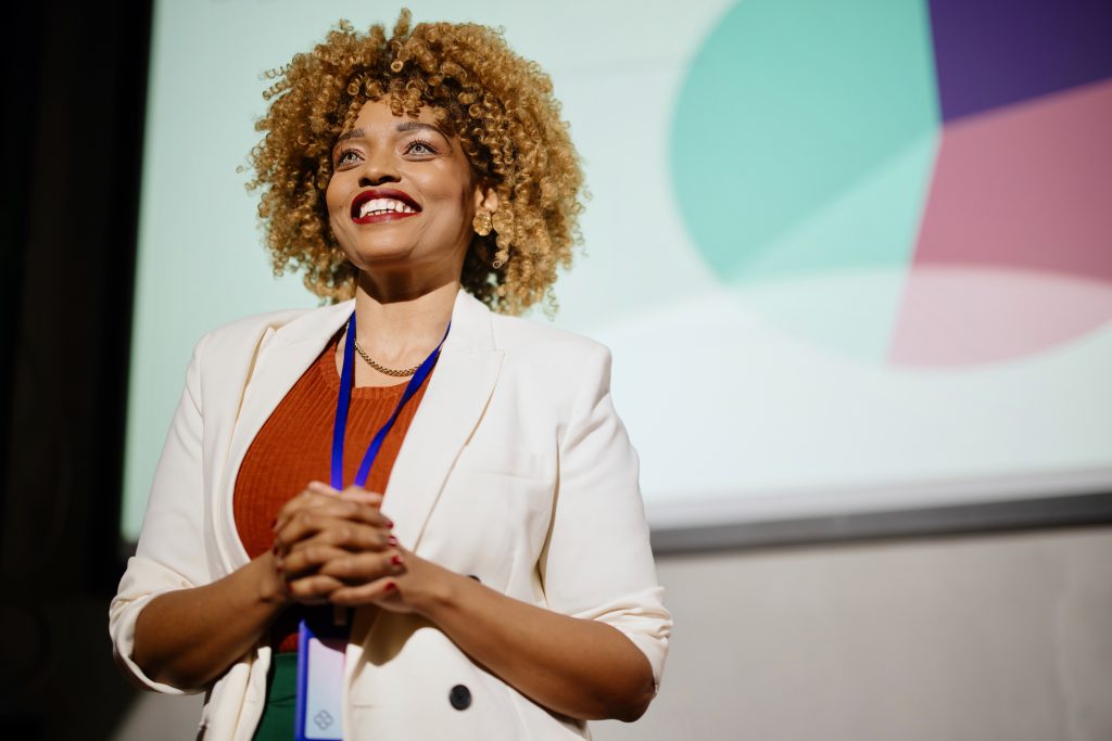 Female professional giving presentation at a conference.