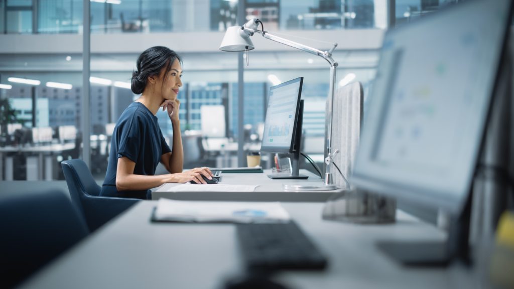 A woman working on a computer in an office.