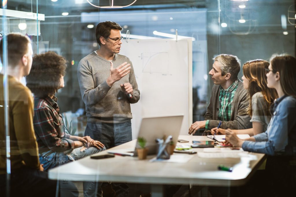 A group of people sitting around a table in a meeting room.